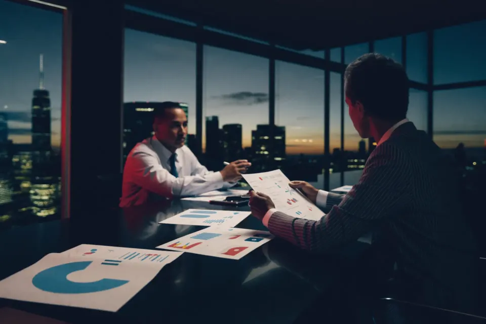 Executives reviewing strategy charts in a boardroom at dusk